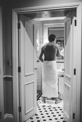 a woman in a towel standing in a bathroom