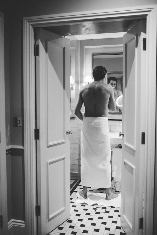a woman in a towel standing in a bathroom