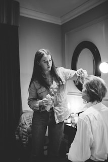 Close-up of a woman spraying halogrow hair spray onto her shiny, thick hair