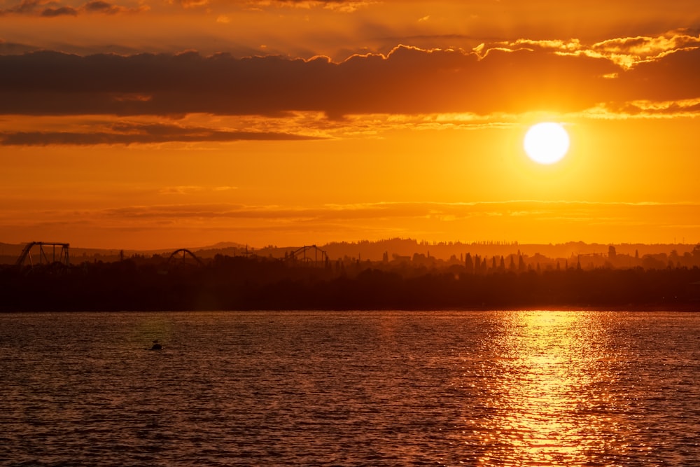 a large body of water with a sunset in the background