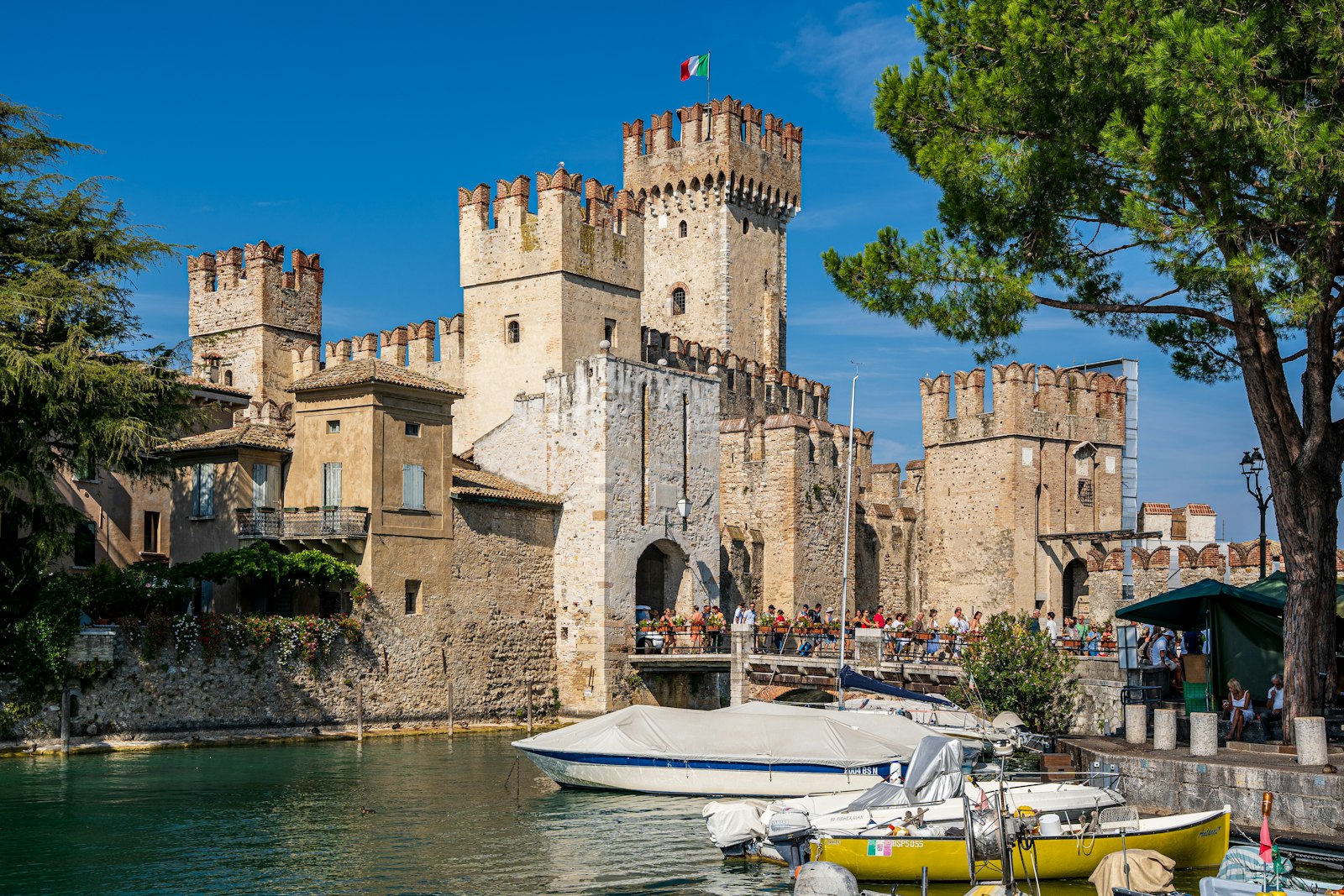 The crenellated towers of Sirmione's Scaliger castle rising from the water of Lake Garda