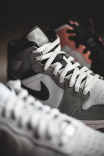 Close-up of the latest trendy sneakers displayed on a sleek white shelf against a graphite gray background.