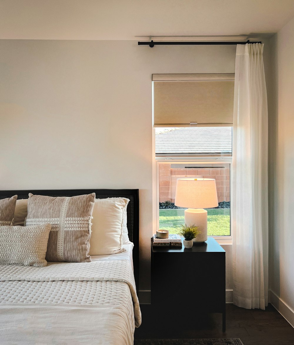 a bedroom with a bed, nightstand, and window