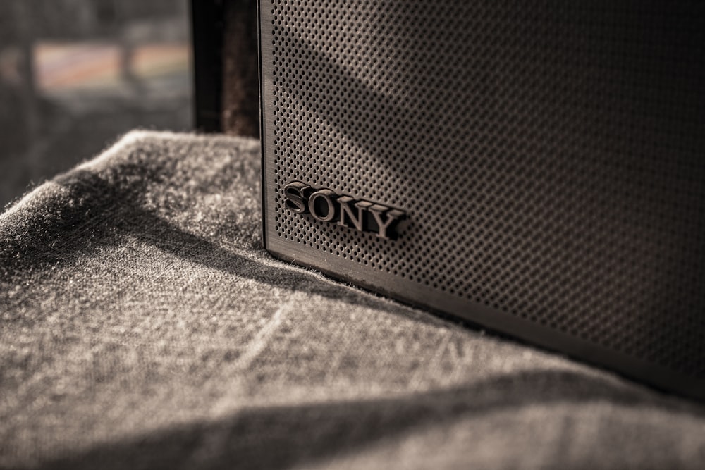 a sony speaker sitting on top of a bed
