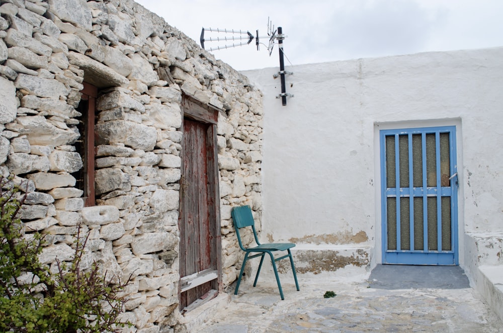 a chair sitting outside of a stone building