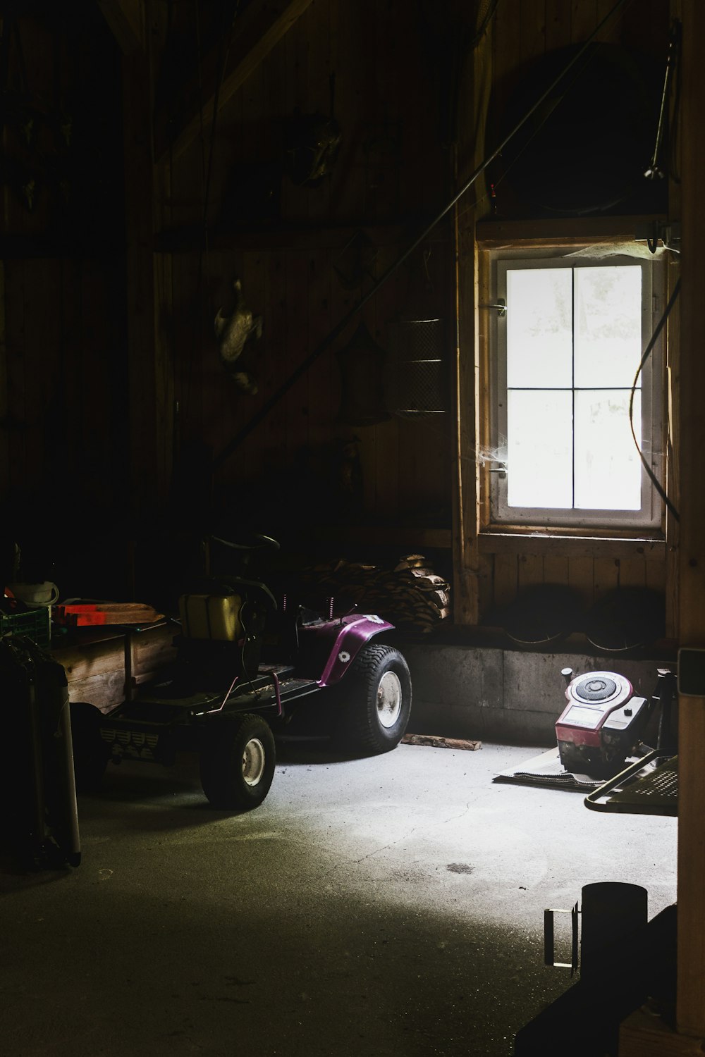 a pink motorcycle parked in a garage next to a window