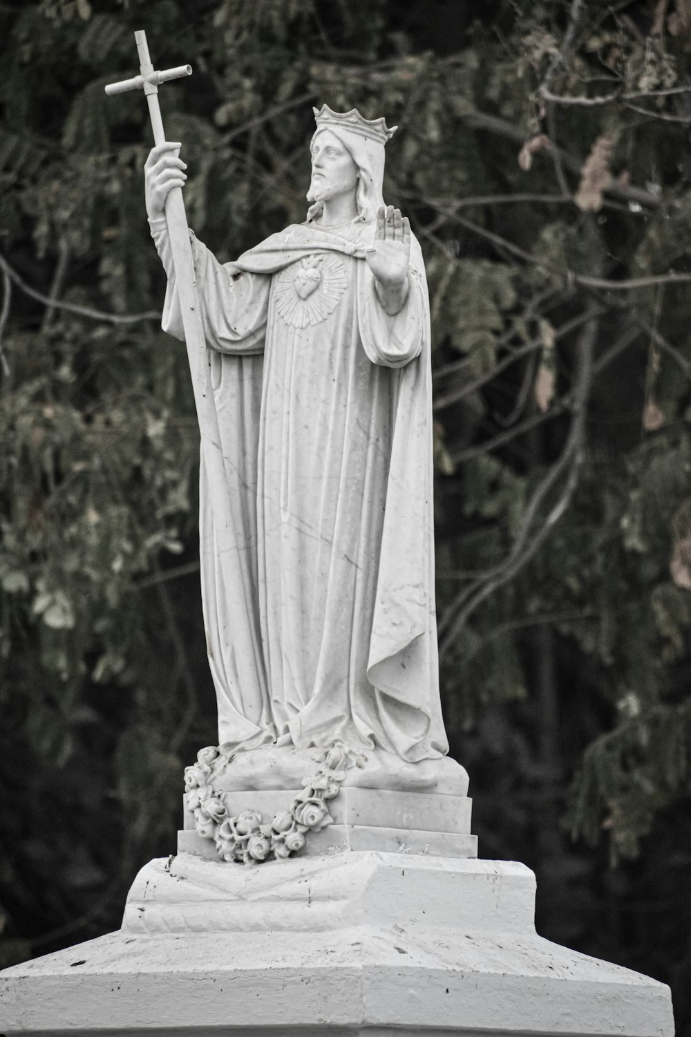 une statue d’une personne tenant une croix