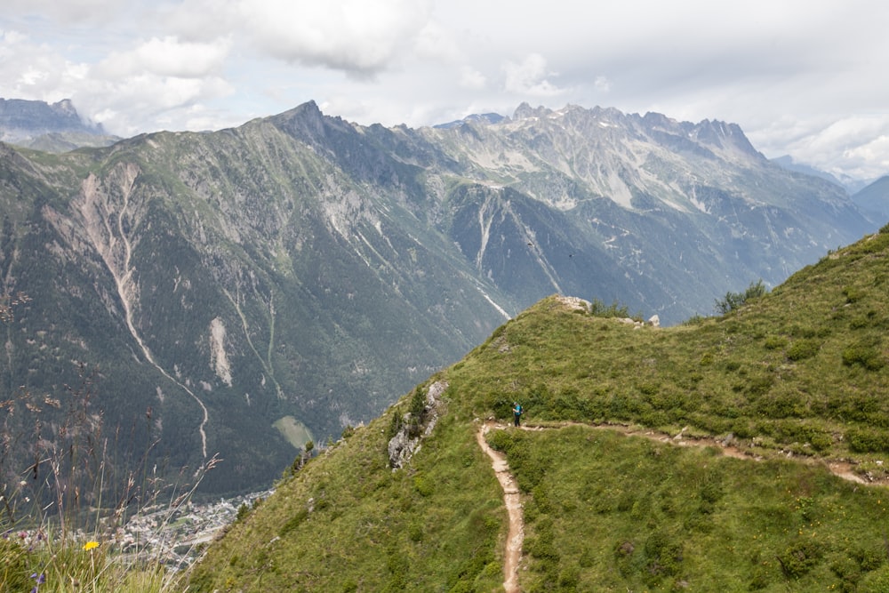 a man walking up a trail on top of a mountain