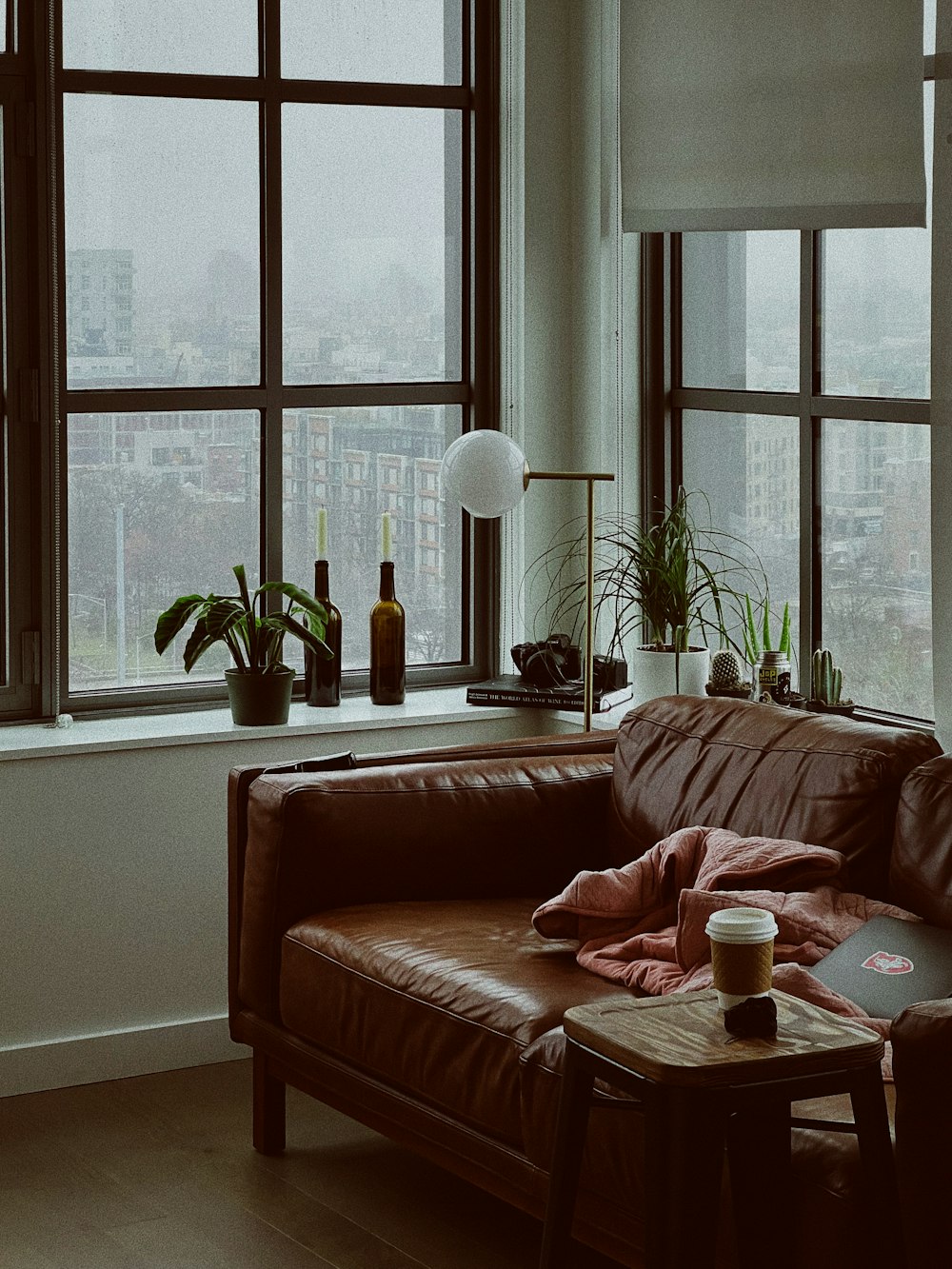 a living room with a leather couch and a window