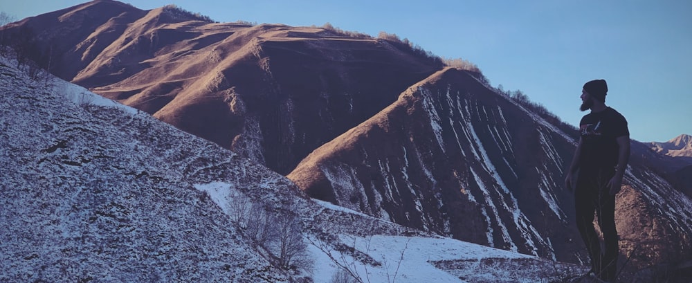 Ein Mann steht auf einem schneebedeckten Berg