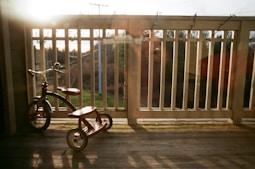 a small wooden tricycle sitting on a deck