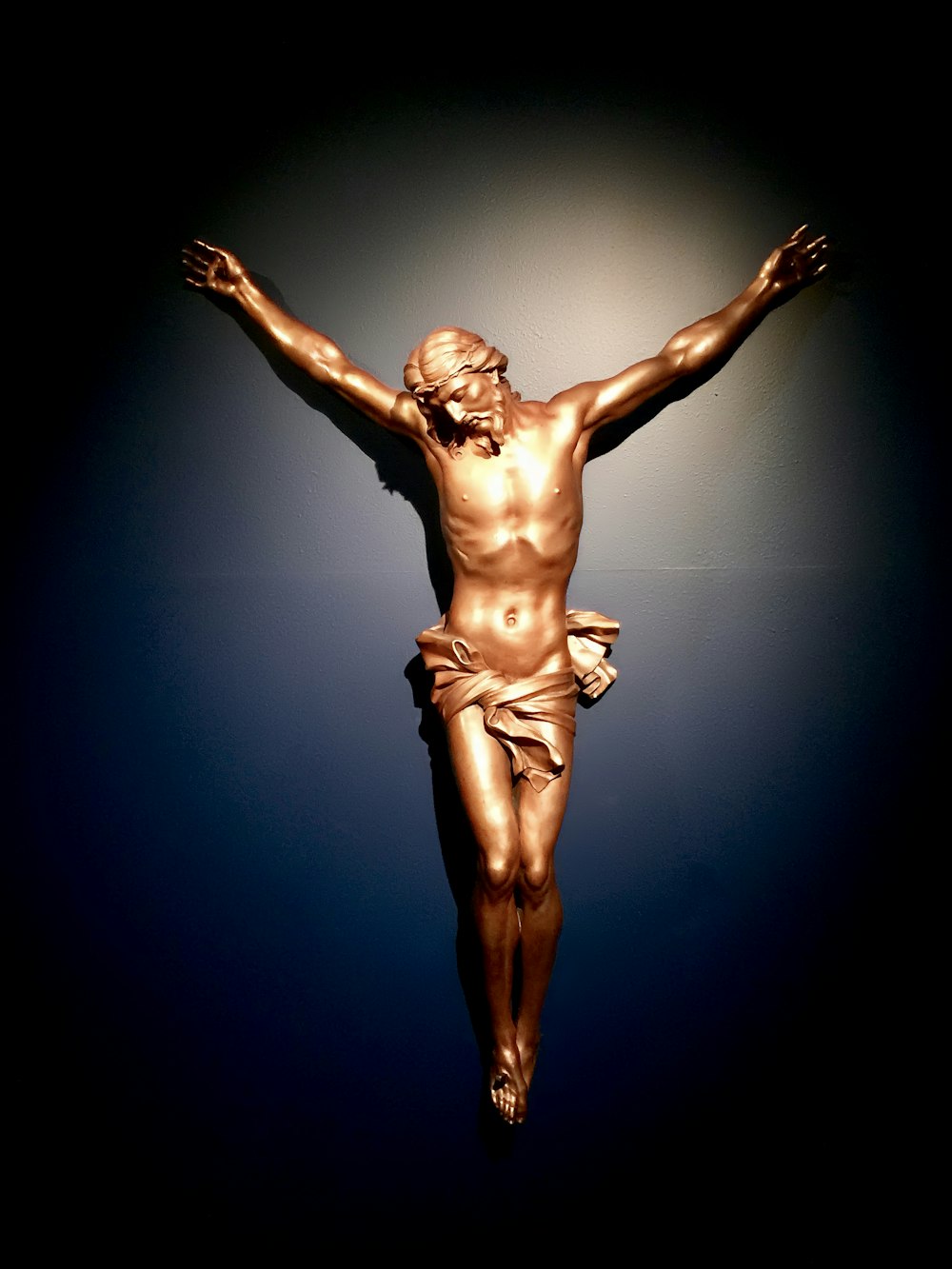 uma estátua de jesus em uma cruz no escuro