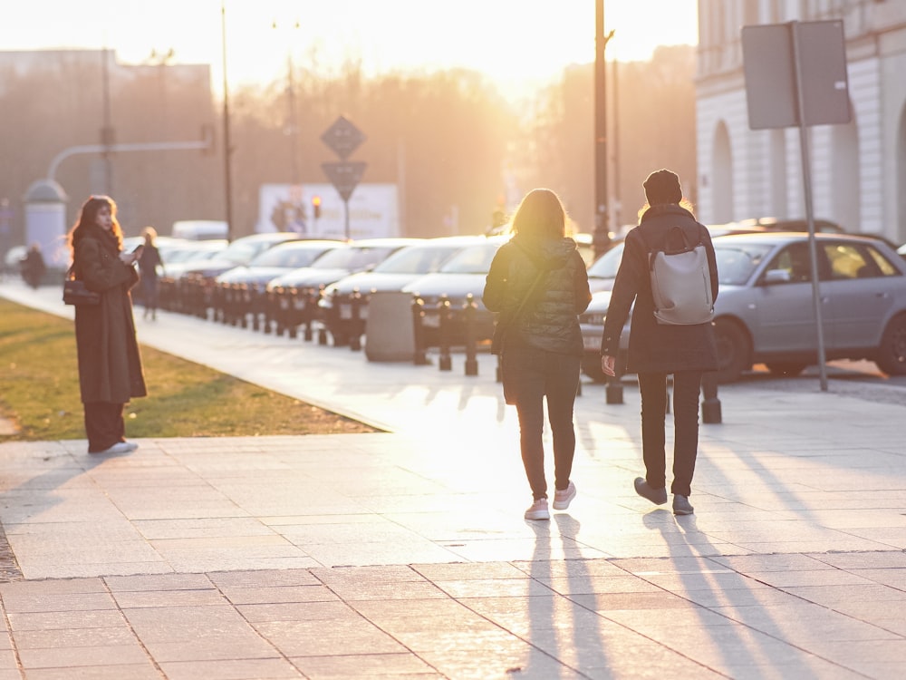 a group of people walking down a sidewalk