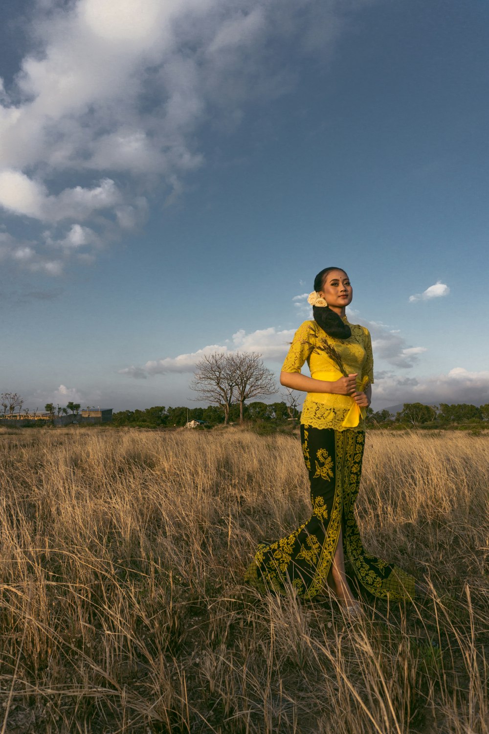 a woman standing in a field of tall grass