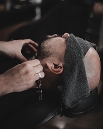 a man getting his hair cut by a barber
