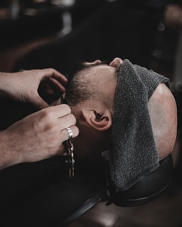 a man getting his hair cut by a barber