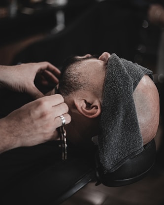 a man getting his hair cut by a barber