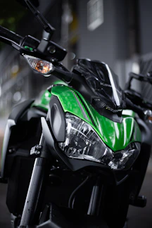 Close-up of a sleek black motorcycle jacket with neon green accents under dynamic lighting.