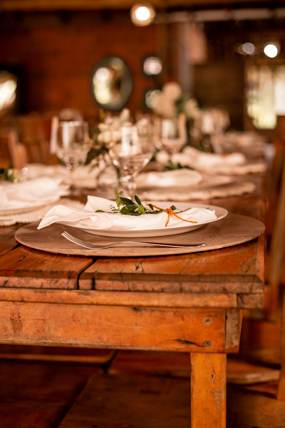 a wooden table topped with plates and glasses