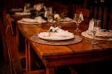 a wooden table topped with a white plate covered in flowers