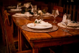 a wooden table topped with a white plate covered in flowers
