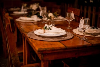 a wooden table topped with a white plate covered in flowers