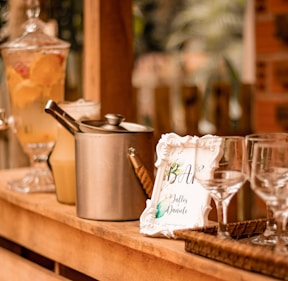 a wooden table topped with glasses and a pot