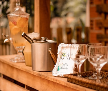 a wooden table topped with glasses and a pot