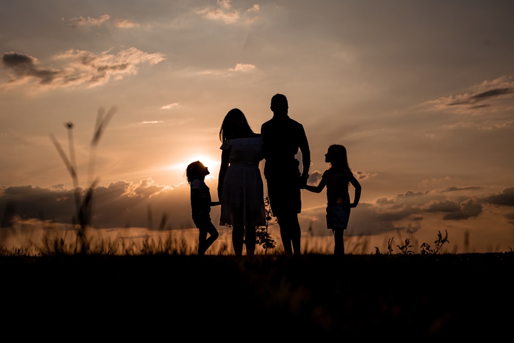 a family standing in a field at sunset