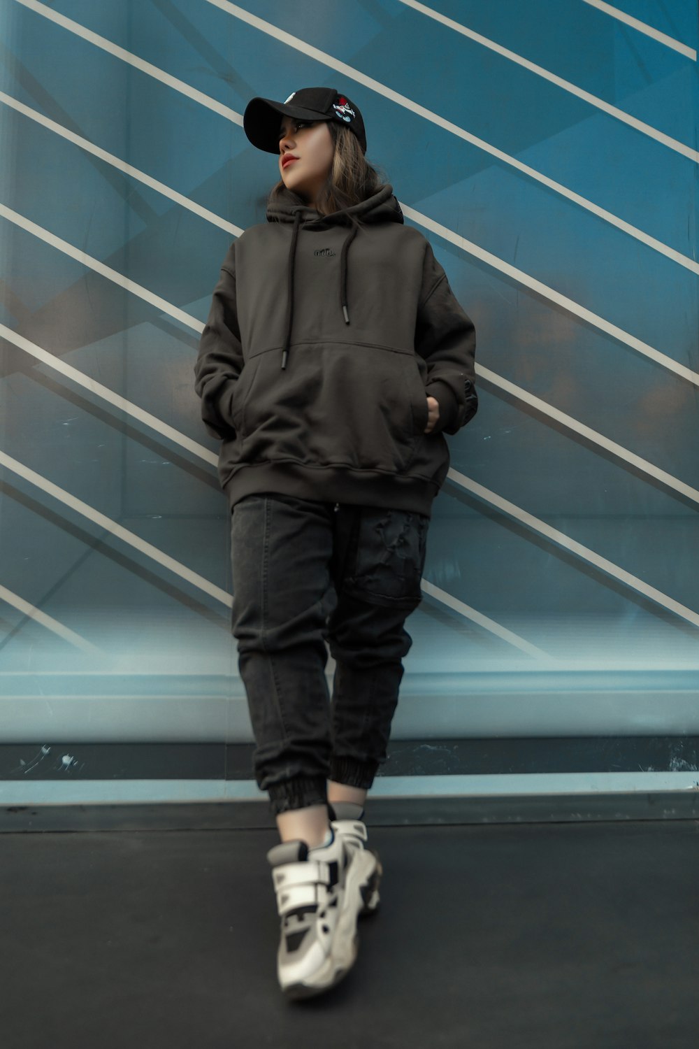 a woman in a black hoodie and white sneakers