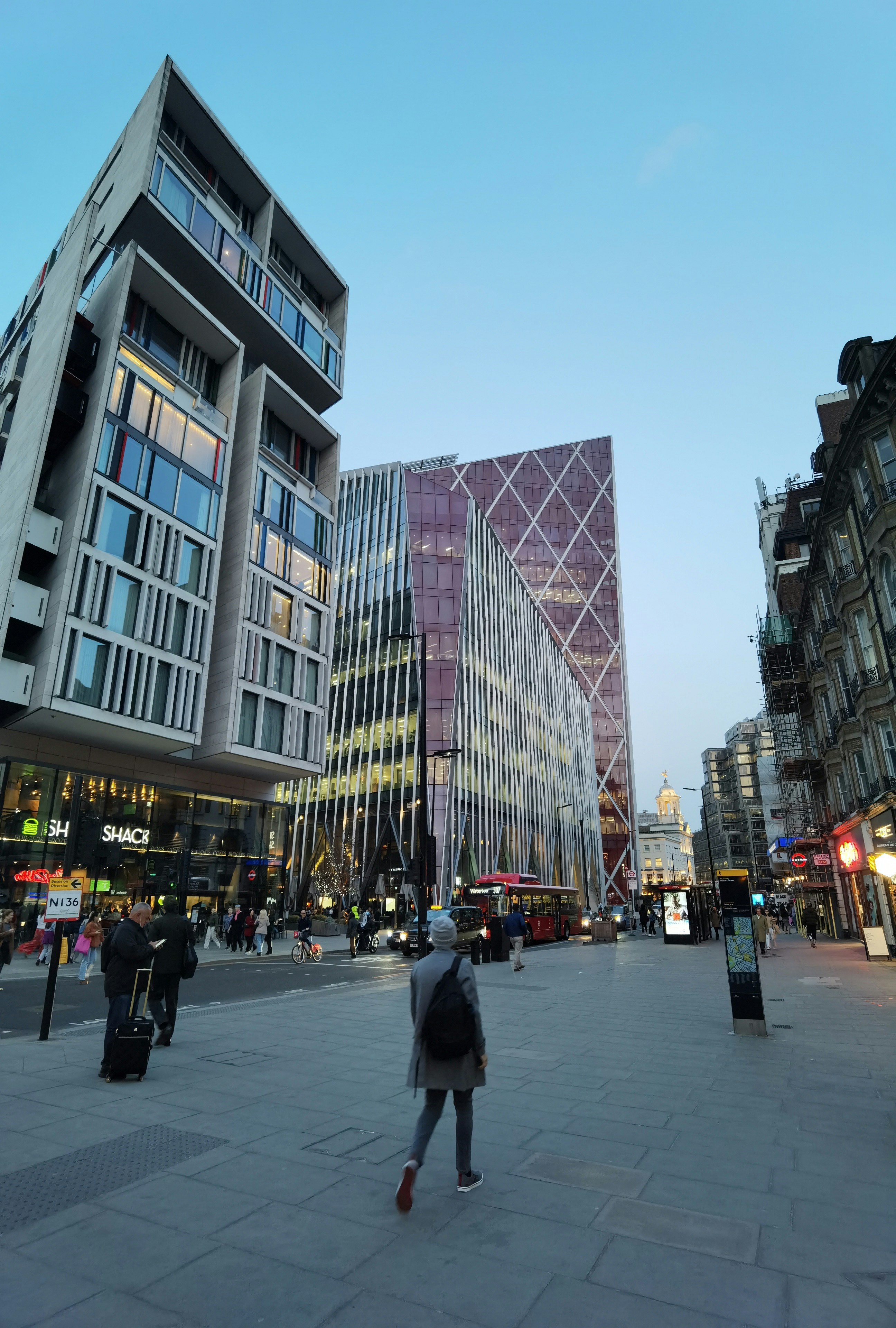 a person walking down a street in front of tall buildings