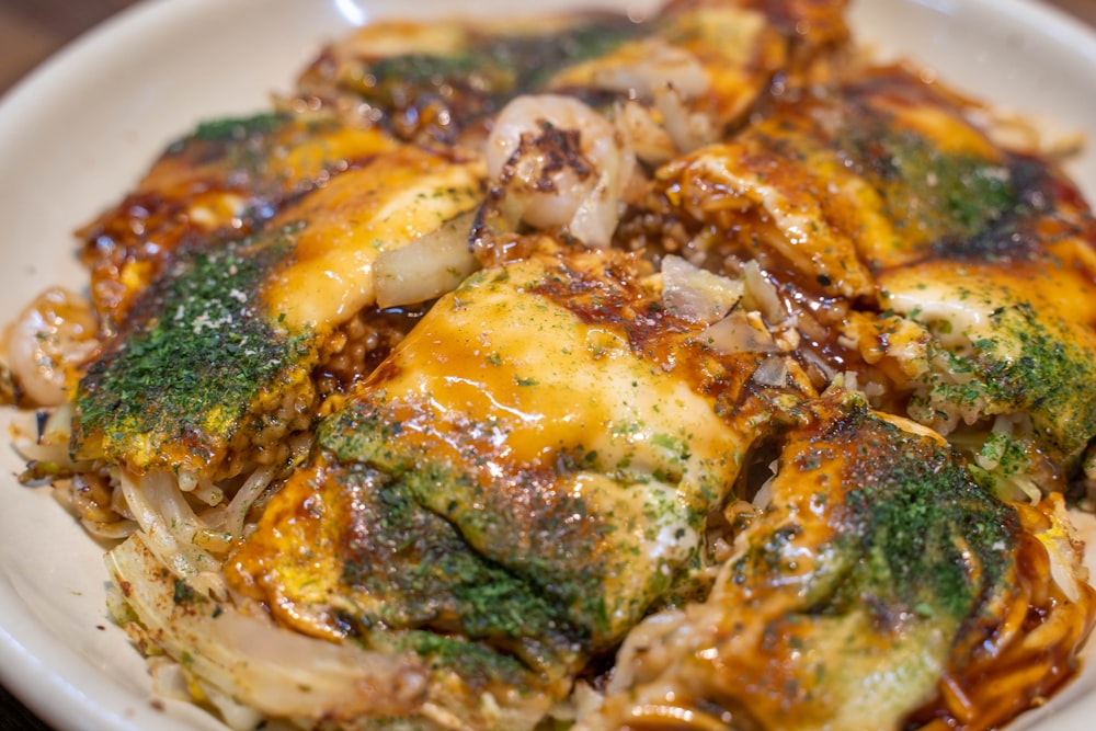 a white plate topped with broccoli covered in cheese