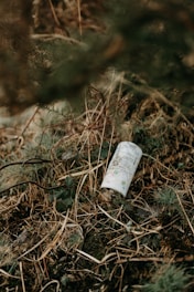 an empty bottle is sitting in the grass