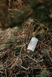 an empty bottle is sitting in the grass