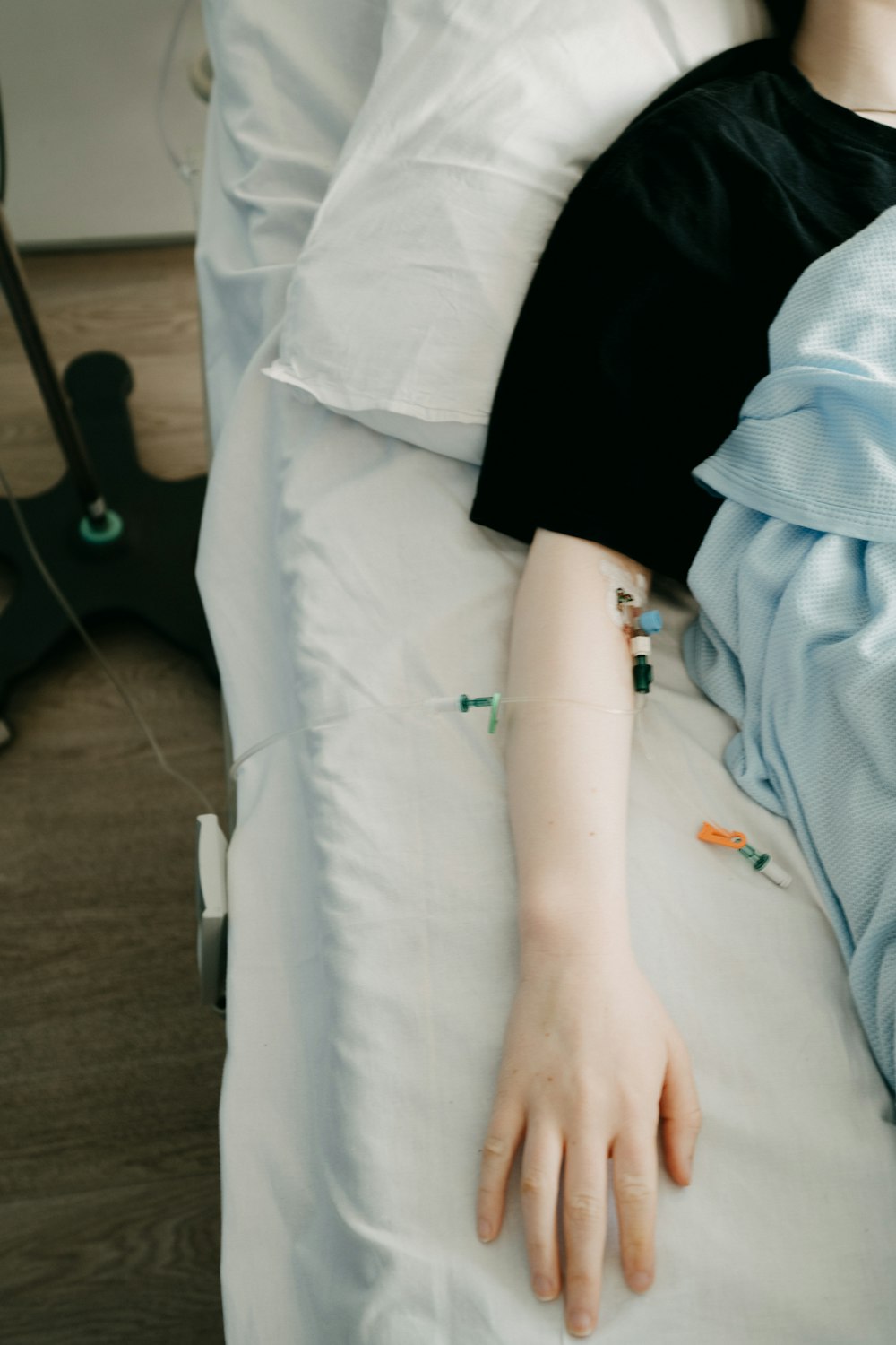 uma mulher deitada em uma cama de hospital com a mão no travesseiro