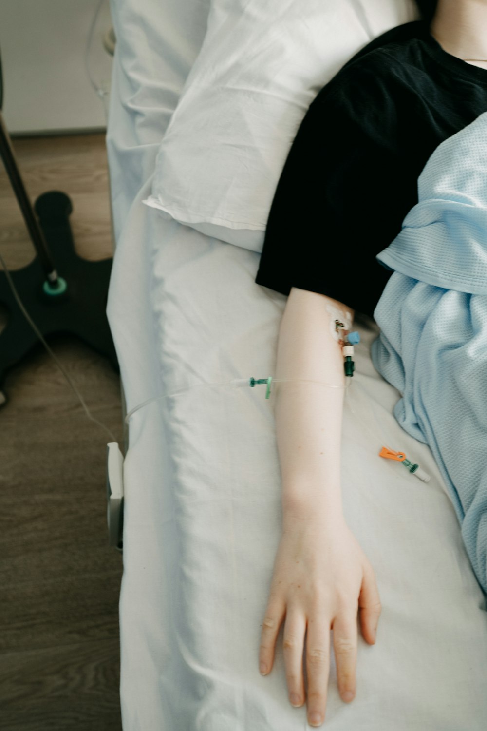 a woman laying in a hospital bed with her hand on the pillow