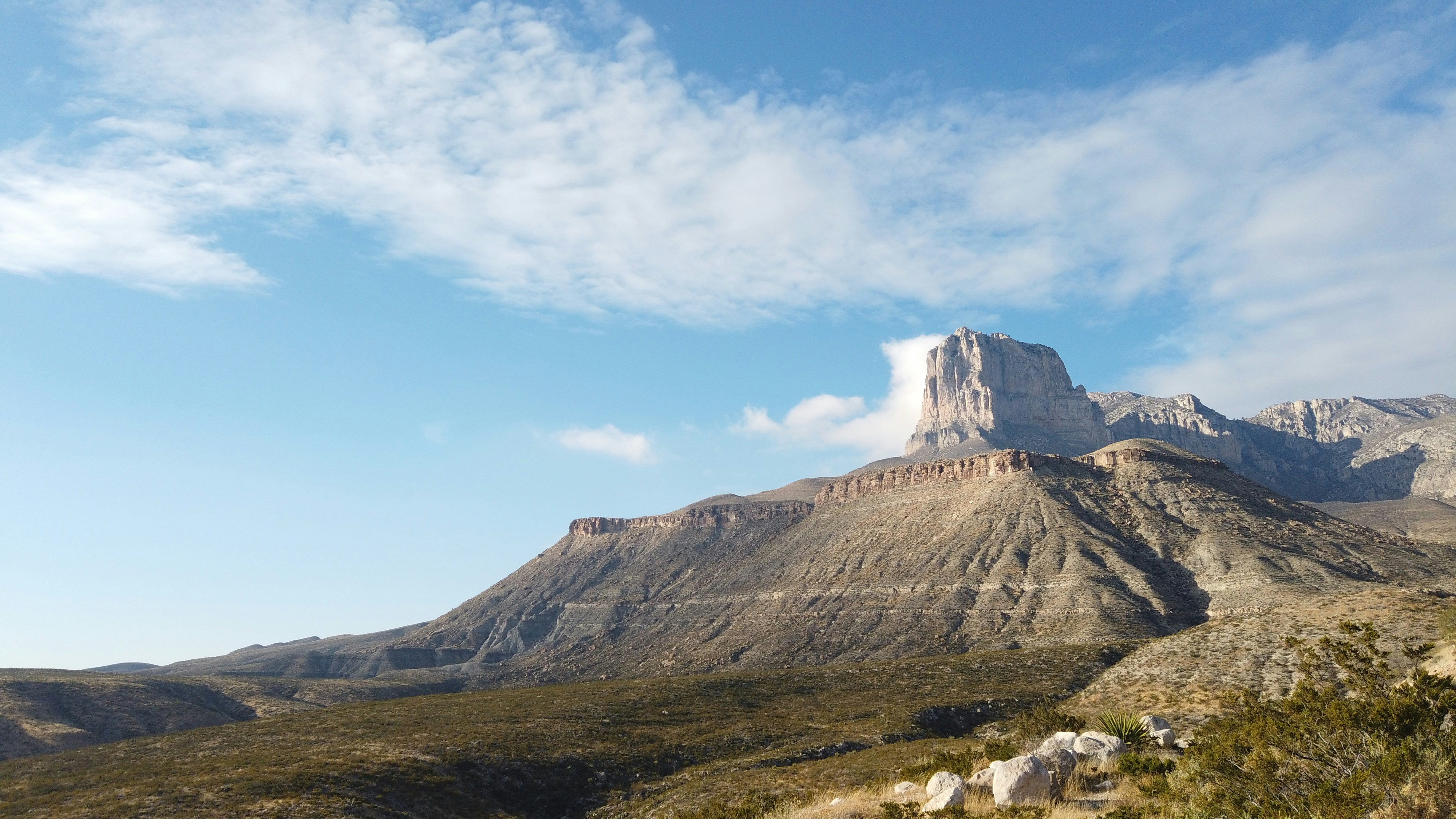 a view of a mountain with a cloud in the sky