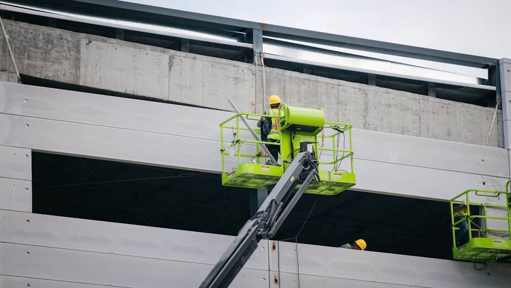 Un uomo su una forbice che lavora sul lato di un edificio