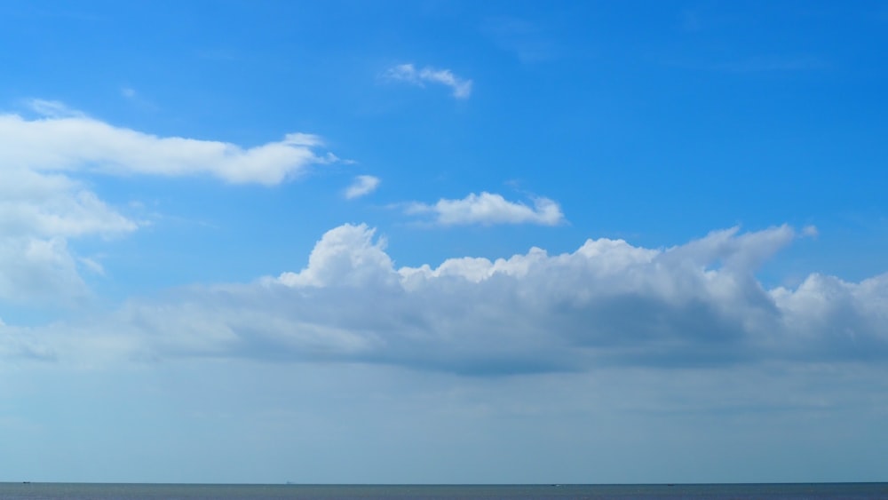 a large body of water under a cloudy blue sky