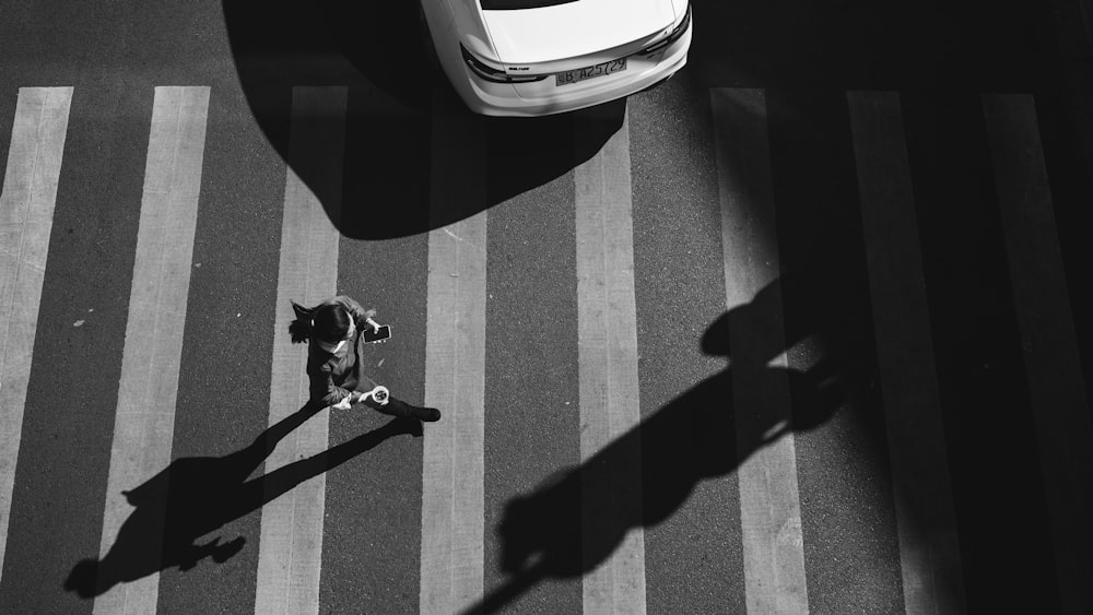 a black and white photo of a person crossing the street