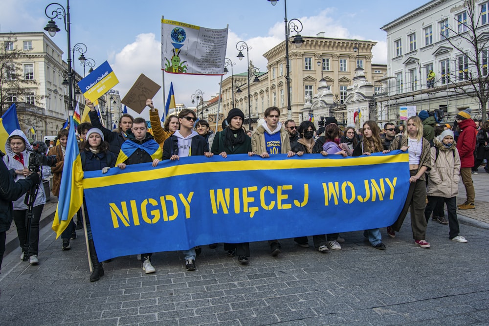 a group of people holding a blue and yellow banner