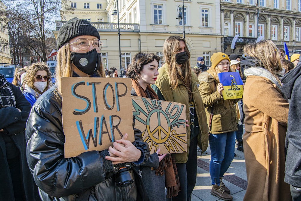 a group of people standing around each other holding signs