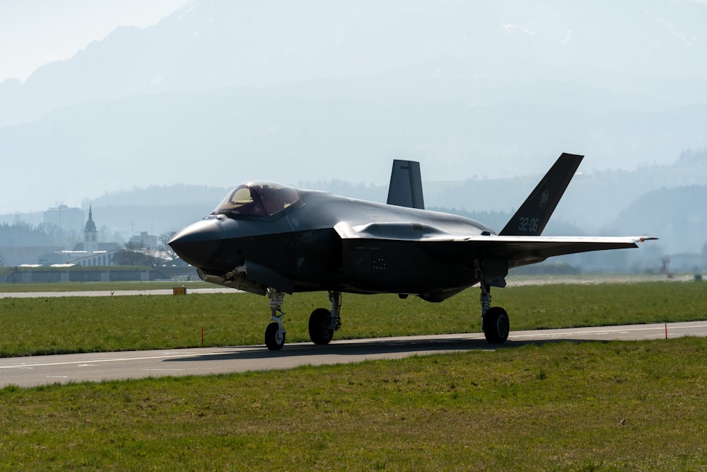 a fighter jet sitting on top of an airport runway