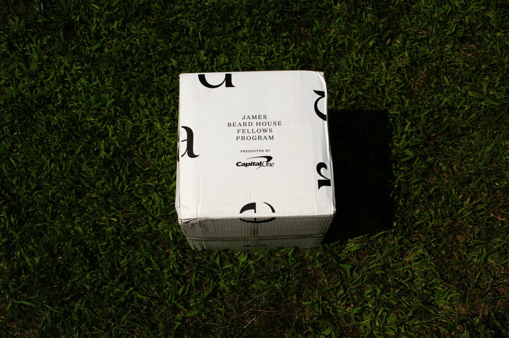 a white box sitting on top of a lush green field