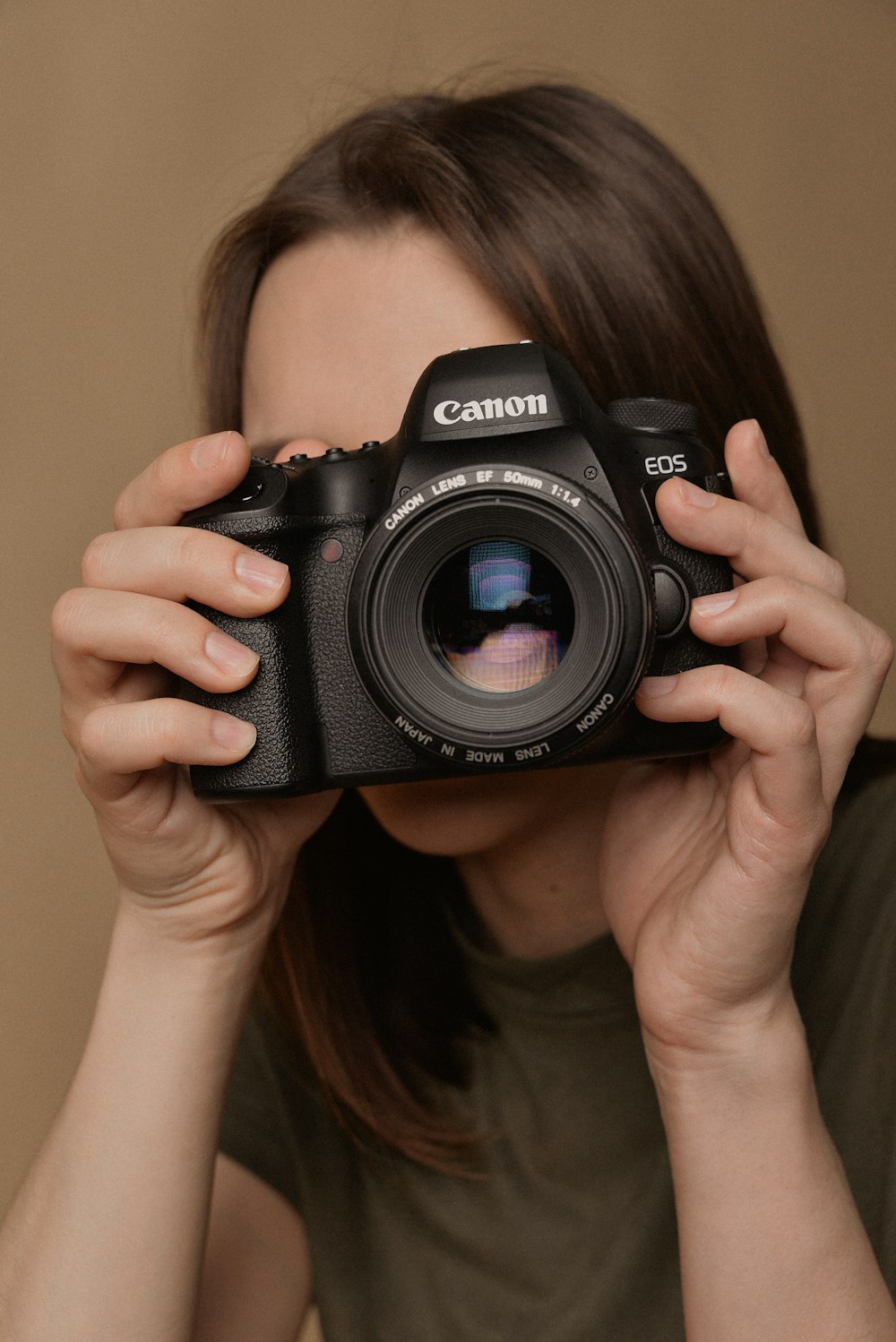 a woman holding a camera up to her face