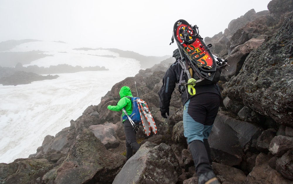 a couple of people walking up a rocky hill