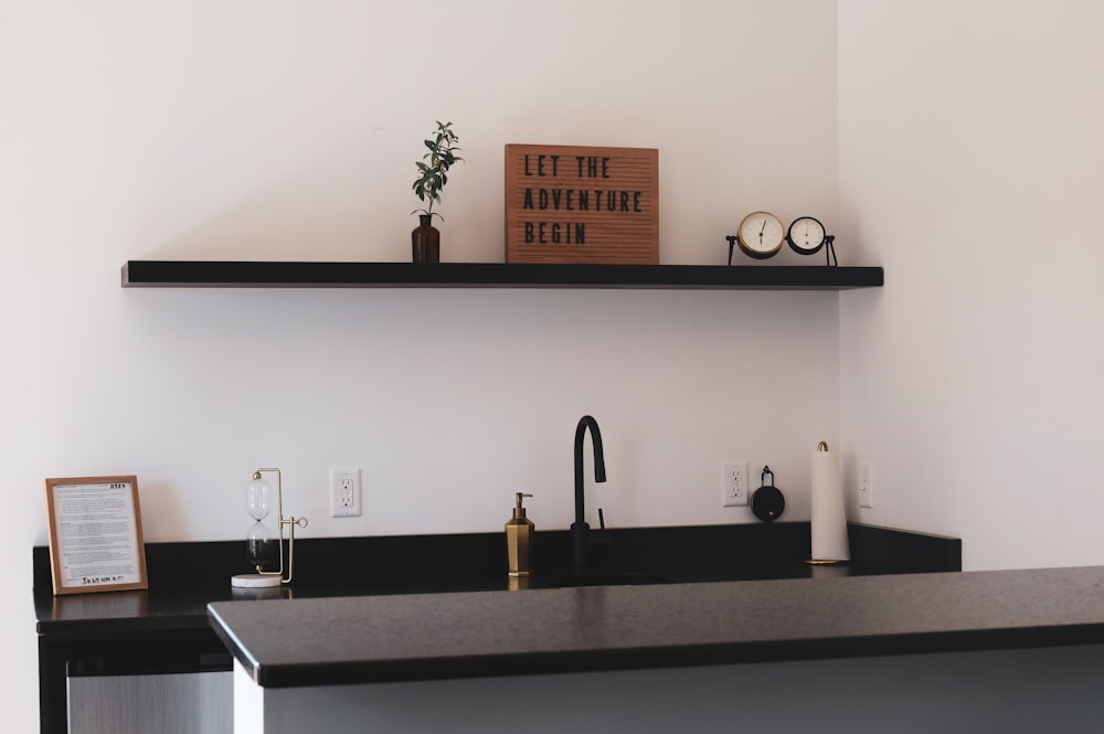 a kitchen with a black counter top and a shelf above it