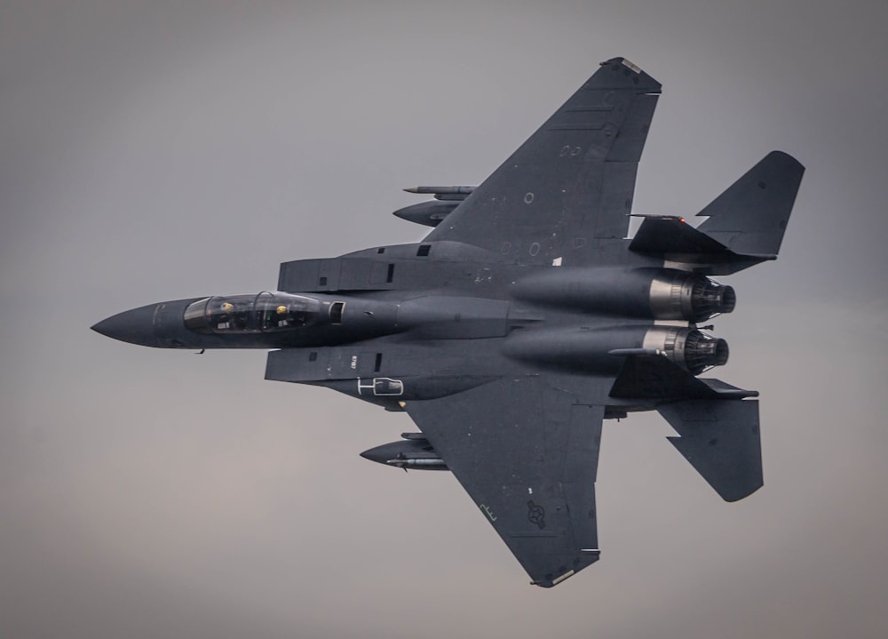 a fighter jet flying through a cloudy sky