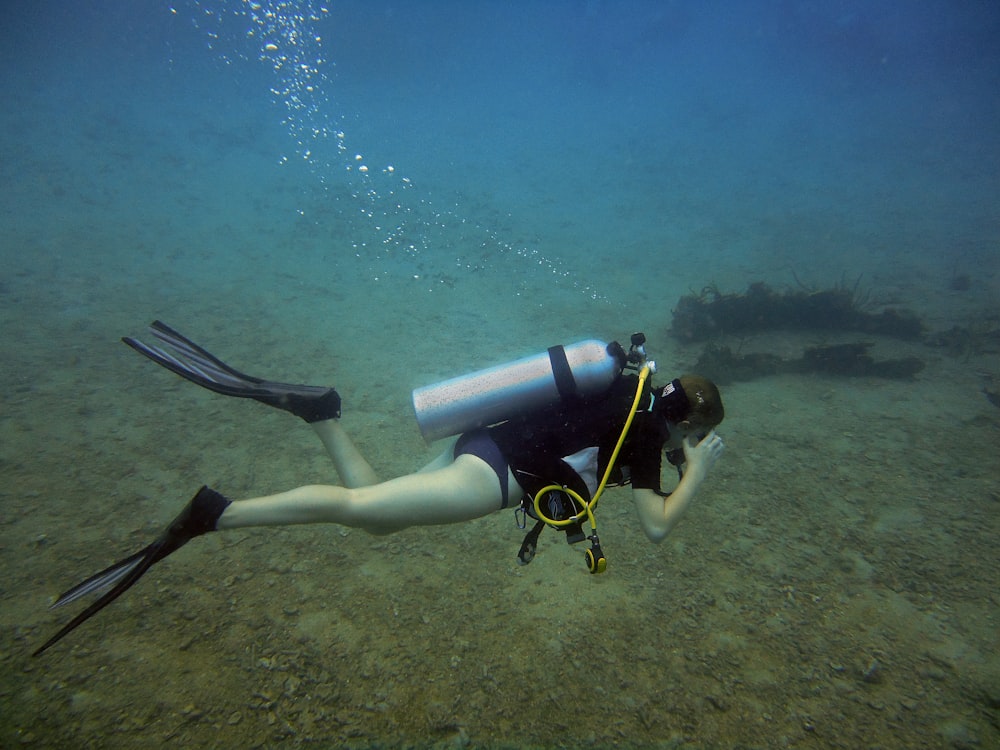 a woman scubas in the water with a scuba pole