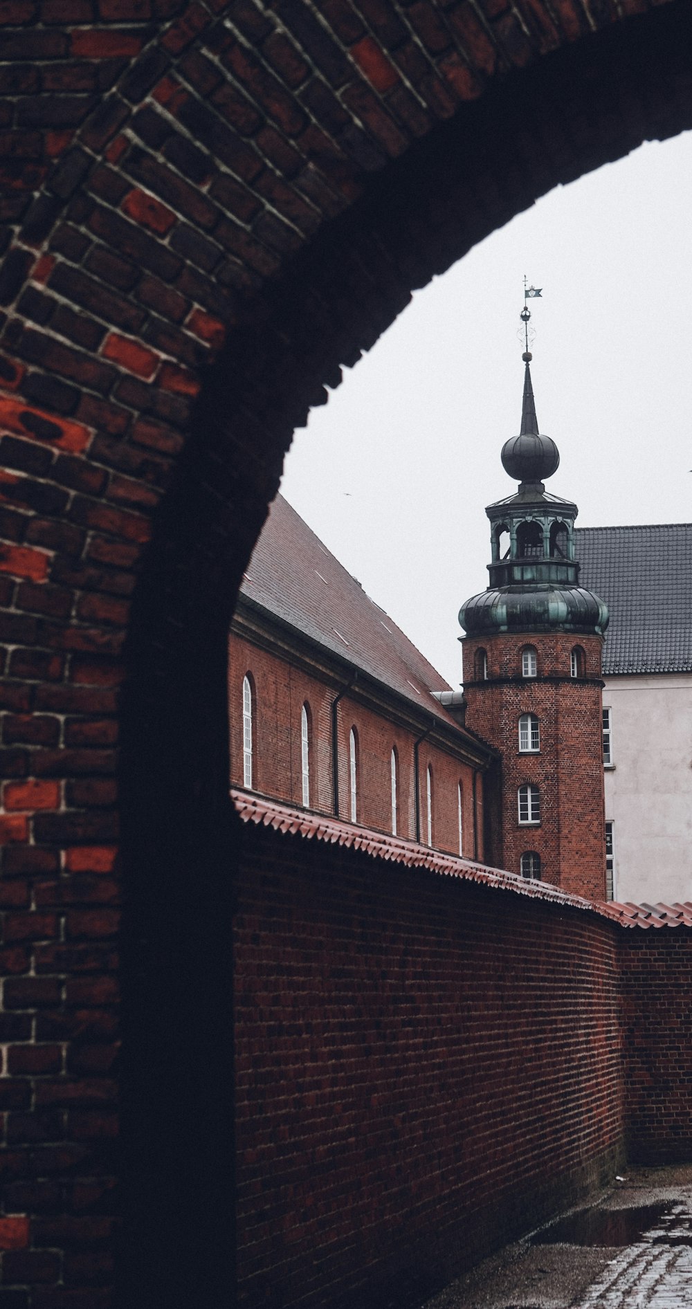 a brick wall with a clock tower in the background